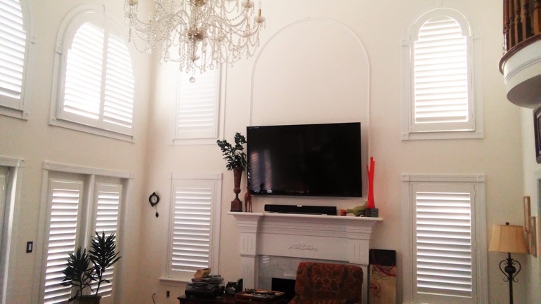 Miami great room with mounted television and arc windows.